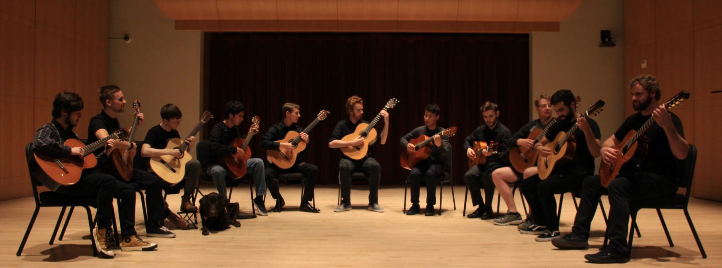Guitar ensemble in a half circle on stage