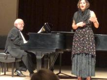 Singer standing in front of piano and pianist and singing