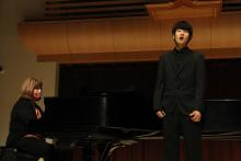 Chihiro Fujii singing on stage with an accompanist