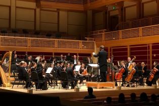 Orchestra onstage with Alex Kahn conducting