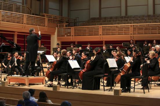 Dr. Kahn conducting the orchestra on stage