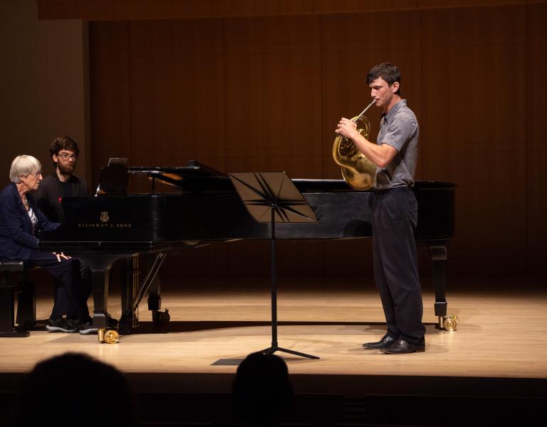 Jason Whitney playing horn on stage
