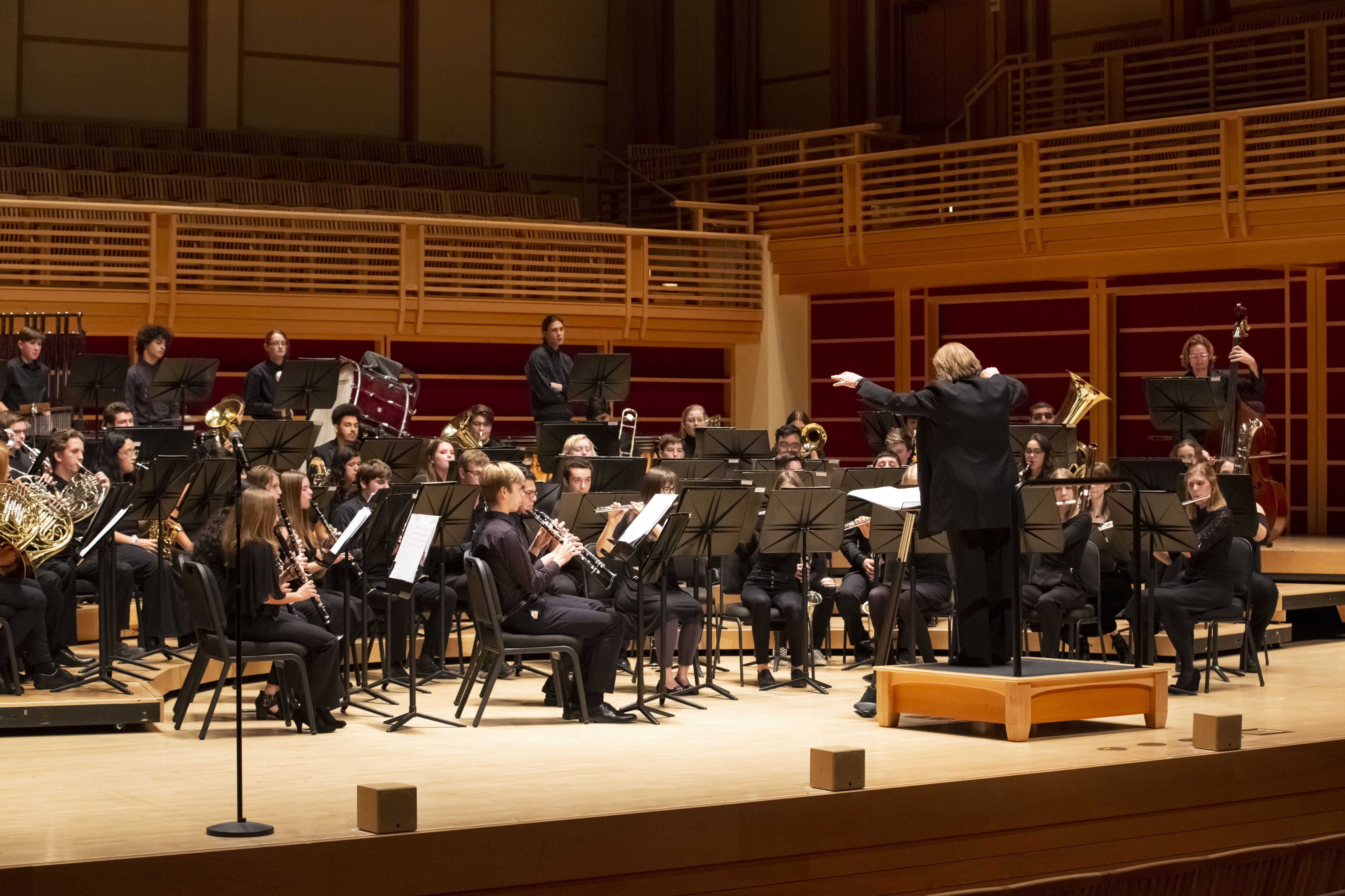 wind band on stage performing with Dr. Kim Mieder conducting