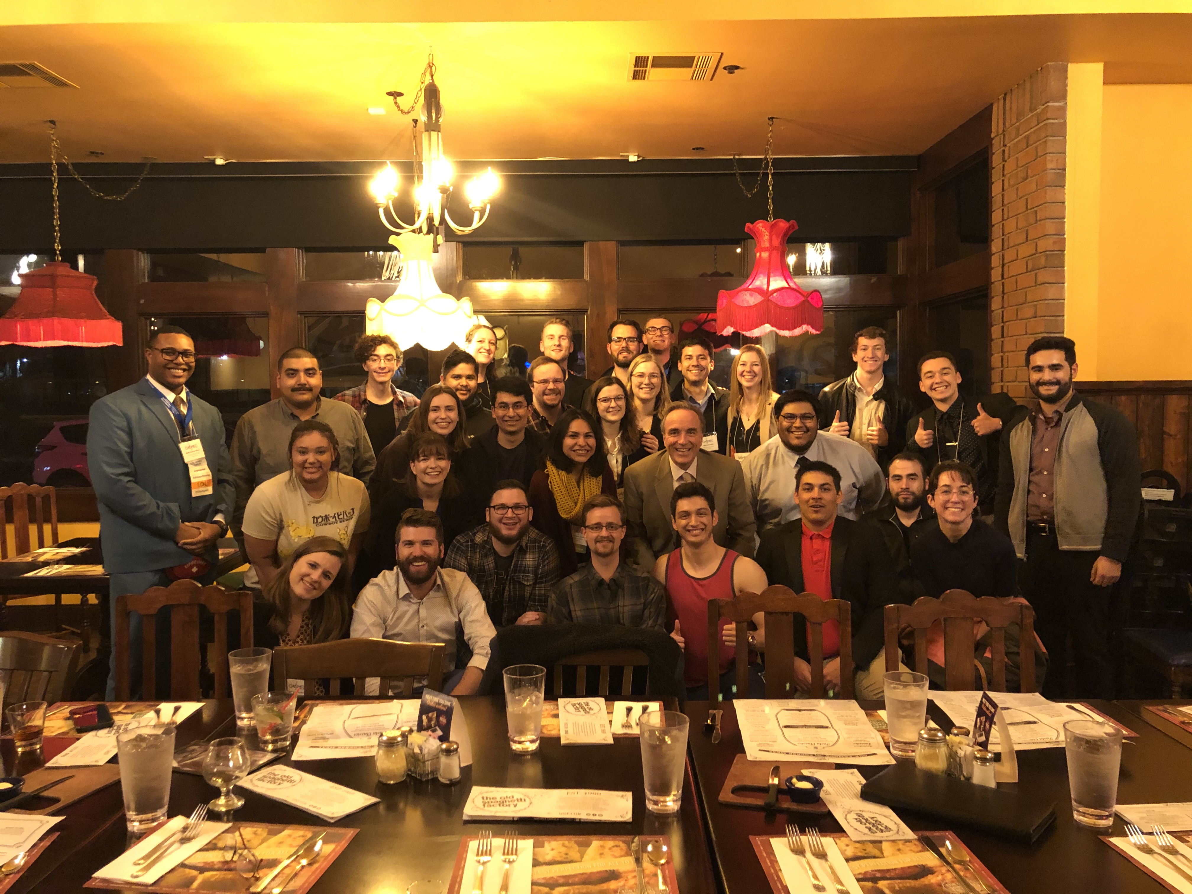 Group picture in a restaurant standing behind a set table