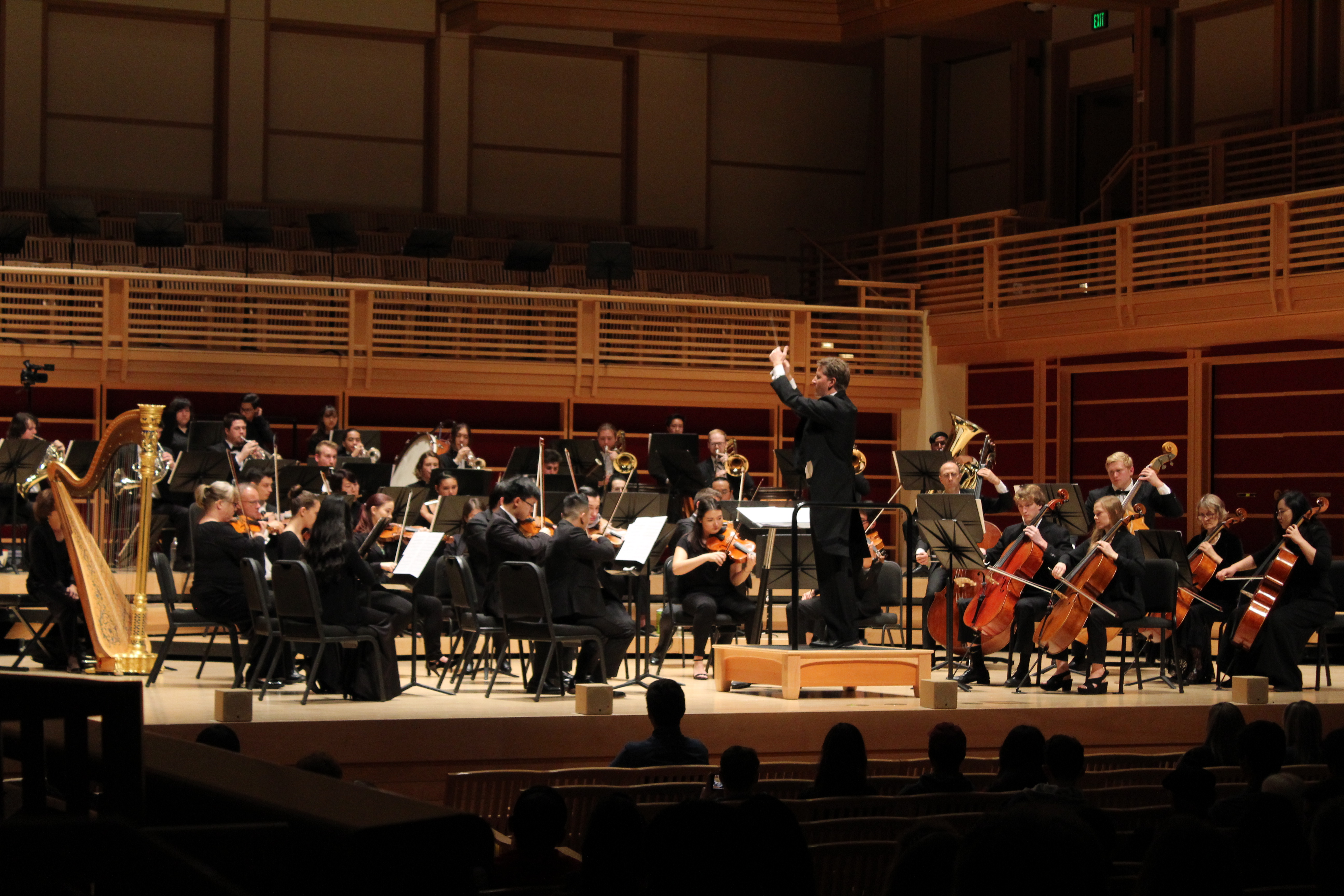 Symphony Orchestra performing onstage with Alexander Kahn conducting