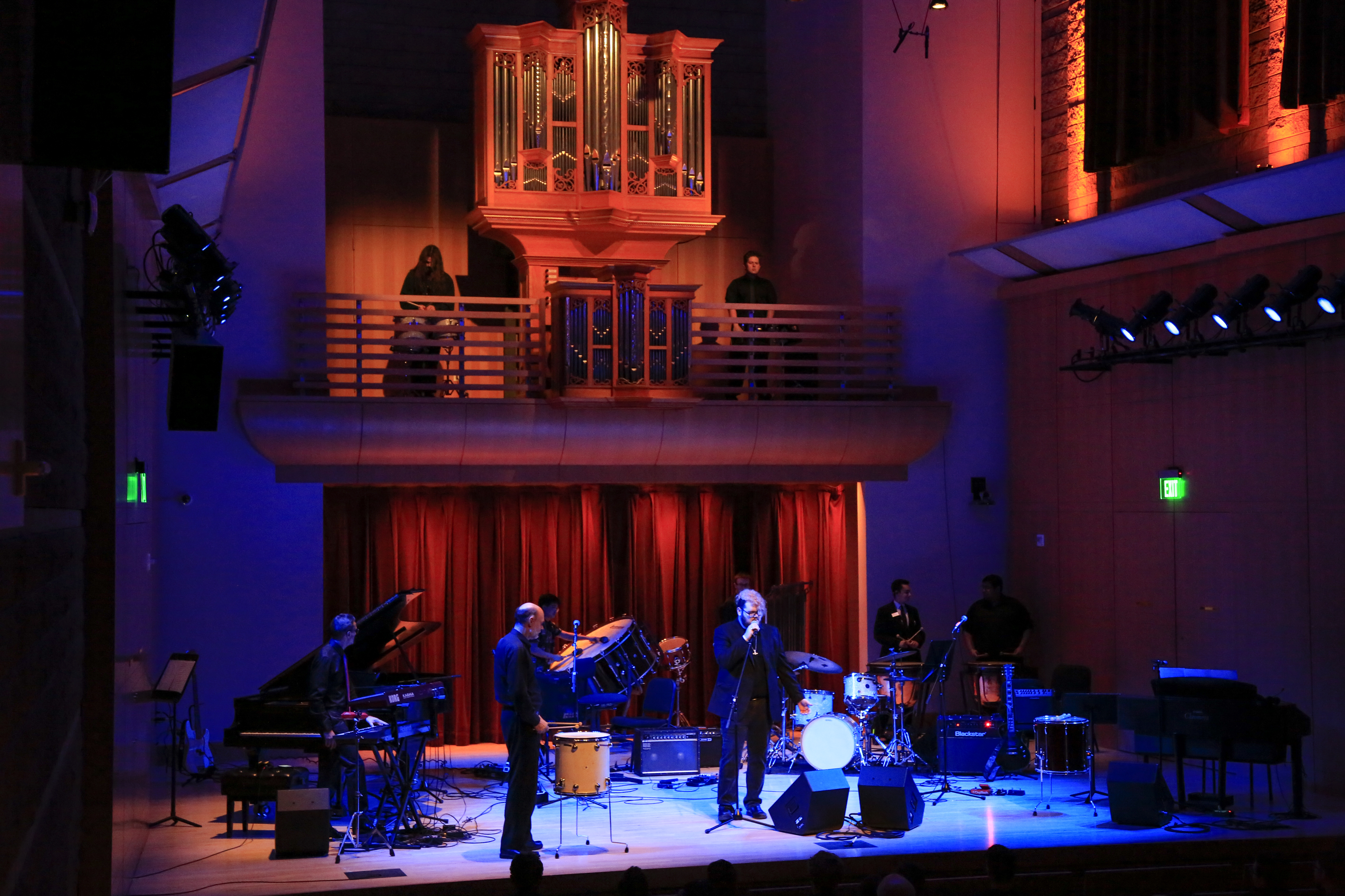 Rock band on stage and drummers in the organ loft