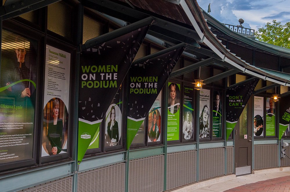multiple screens in an outdoor display at a box office showcasing women in music