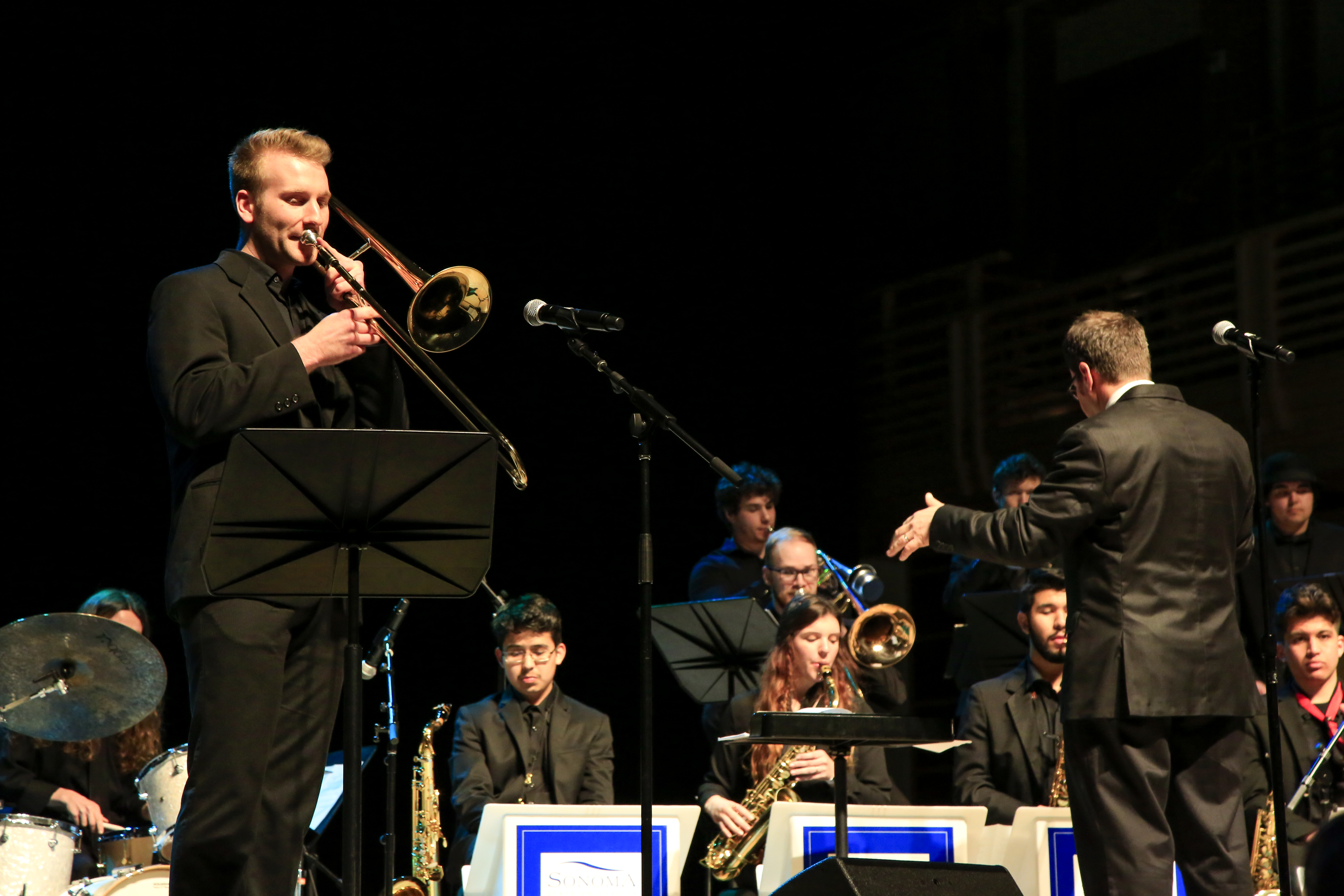 Thomas Gosnell playing soloing on trombone in front of Jazz Orchestra
