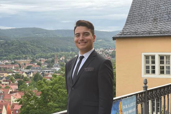 Jack Adkins standing in a suit near railing outdoors