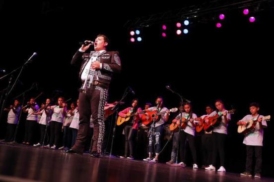 José Soto Jr. singing in front of a group of mariachi students