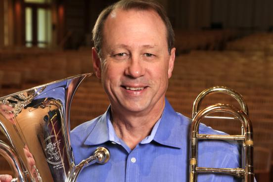 Tony Collins Headshot with trombone and ehuphonium
