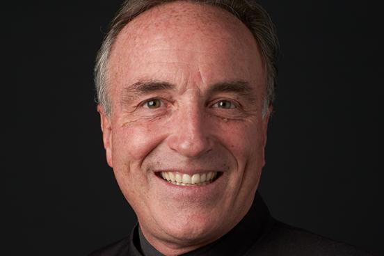 Andy Collinsworth Headshot with black shirt and black background