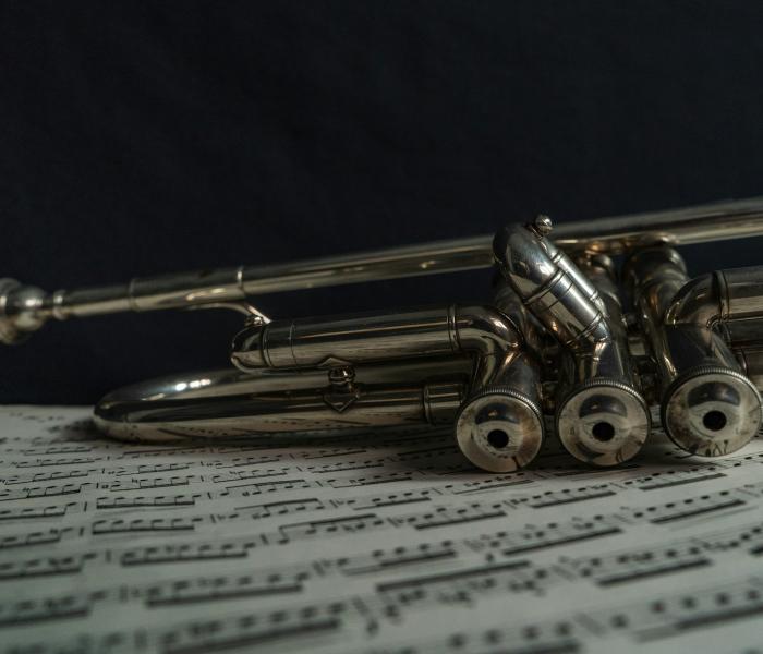Trumpet laid over sheet music