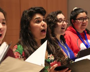 Women singing with their choir folders open