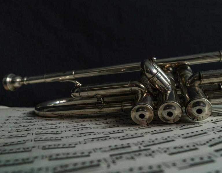 Trumpet laid over sheet music