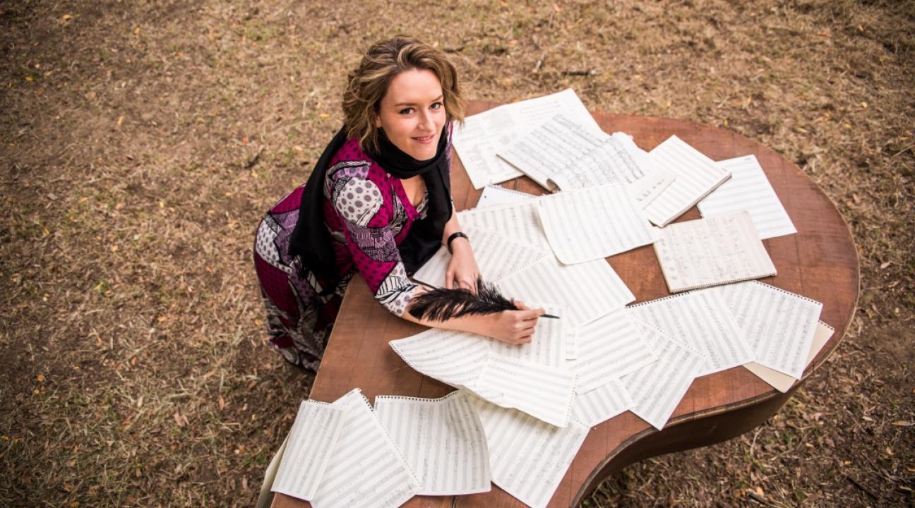 Christa Durand at a desk with sheet music outdoors