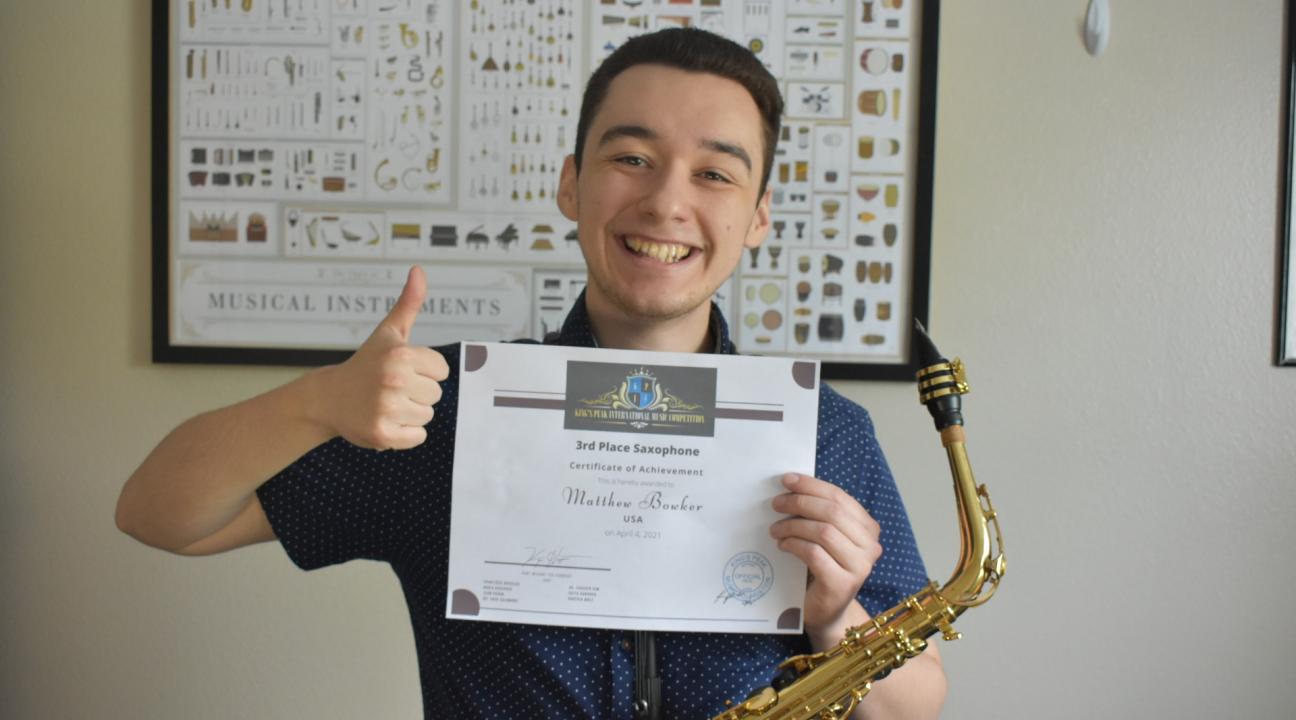 Matthew Bowker holding up certificate 