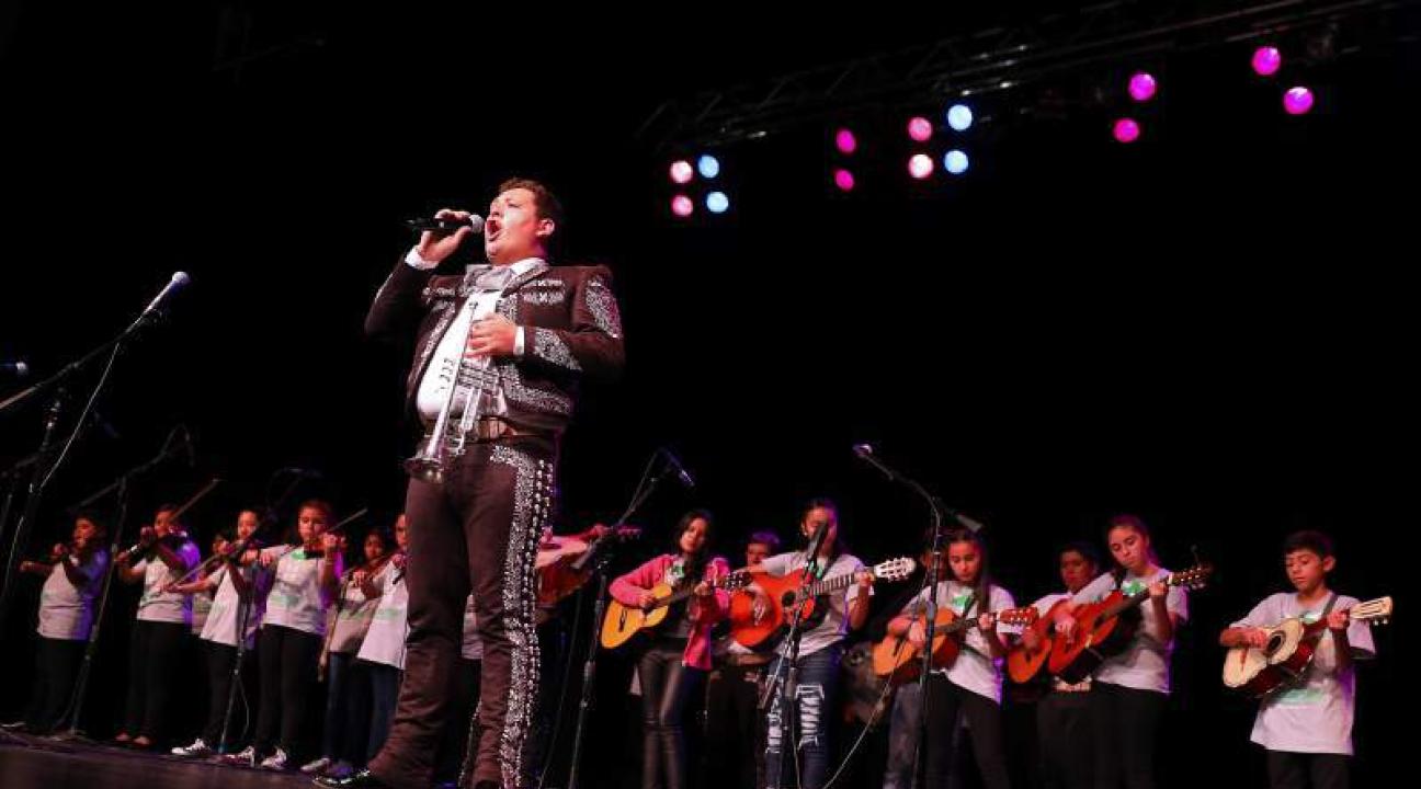 José Soto Jr. singing in front of a group of mariachi students