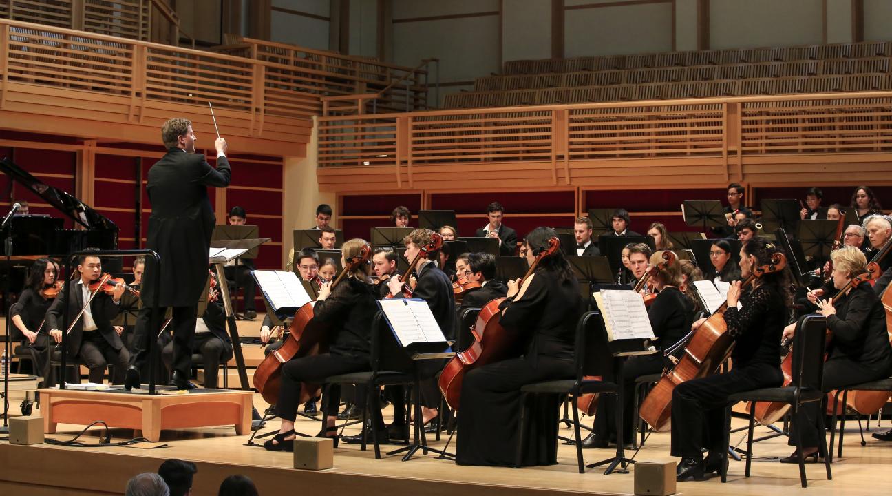 Dr. Kahn conducting the orchestra on stage