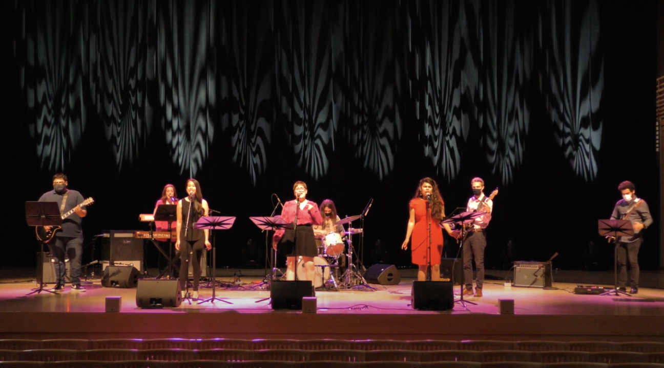Band onstage at Weill hall with three female singers