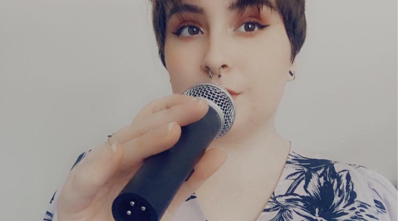 Abbi Samuels holding a microphone to her mouth