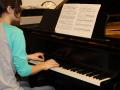 student sitting at piano ready to play