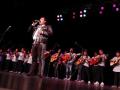 José Soto Jr. singing in front of a group of mariachi students