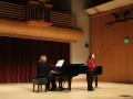 student singing on stage with accompanist