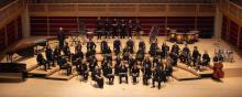 Posed group photo of Wind Ensemble on stage