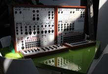Buchla sitting on a green table with light streaking across it
