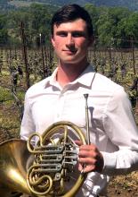 Jason Whitney Headshot with french horn in vineyard