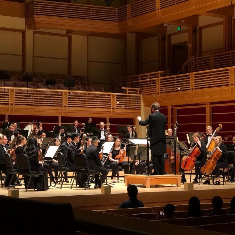 Orchestra onstage with Alex Kahn conducting