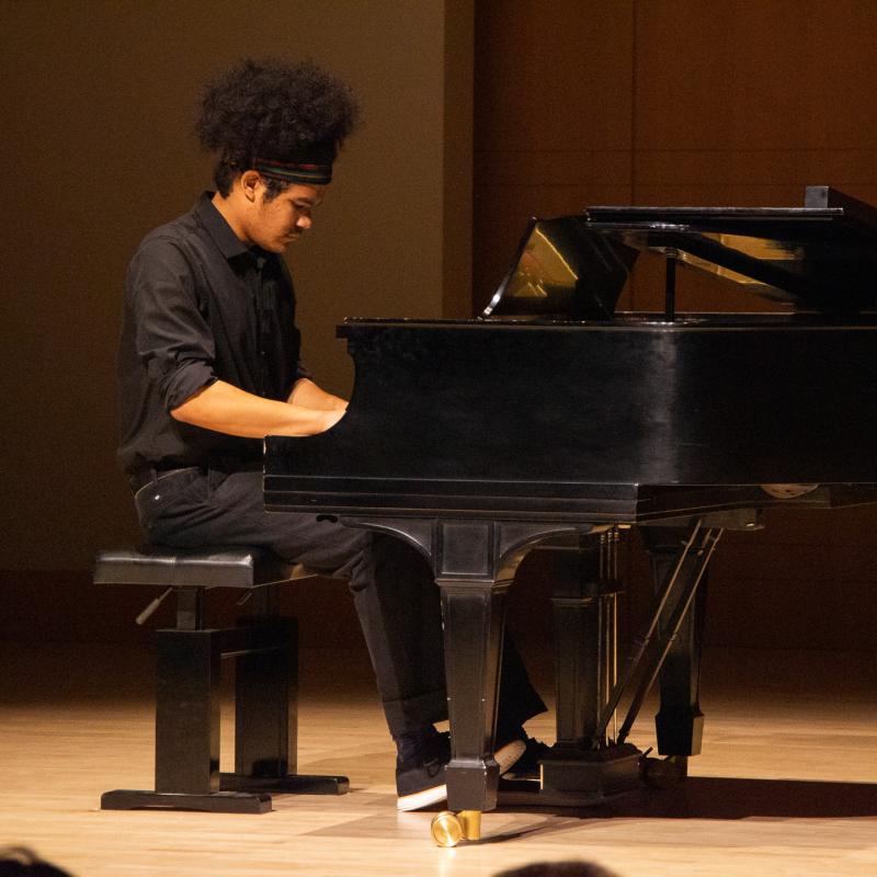 Jomei Greer playing piano in concert black on Schroeder stage