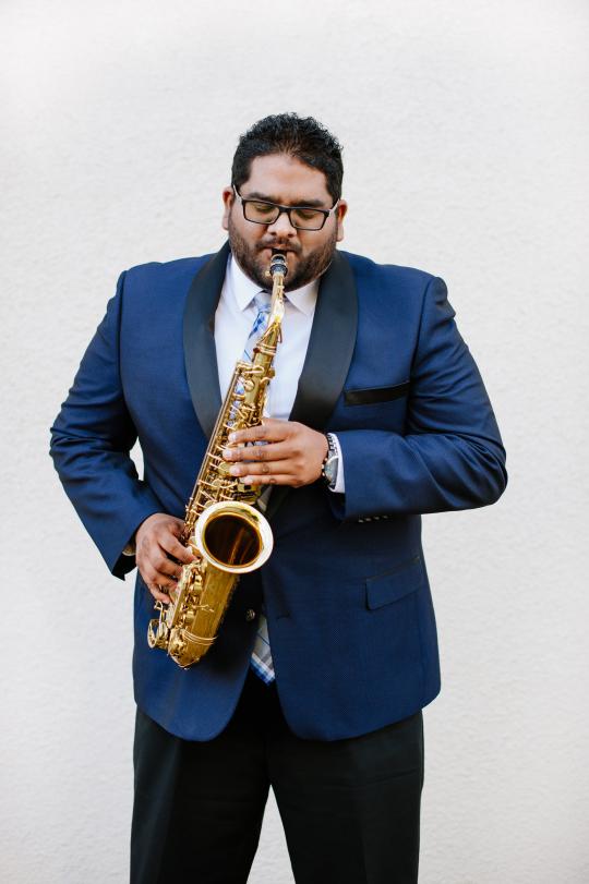 Andrew Harrison headshot playing saxophone