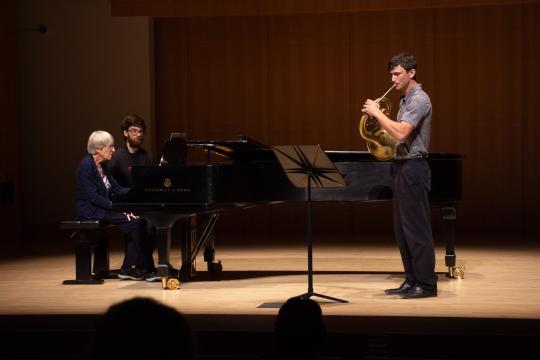 Jason Whitney playing horn on stage