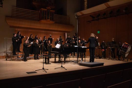 Choir on stage with Jenny Bent directing