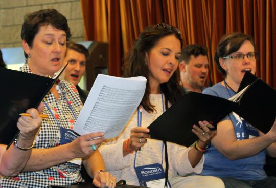 a photograph of a group of women singing