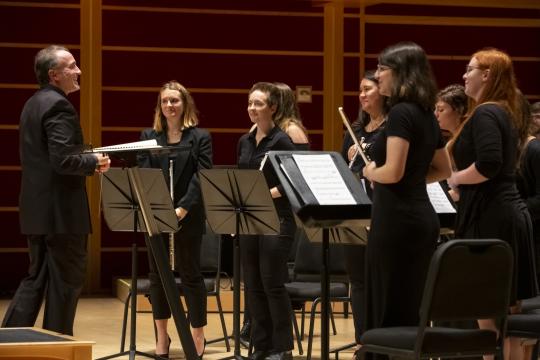 Dr Collinsworth standing in front of his Wind Ensemble - side perspective