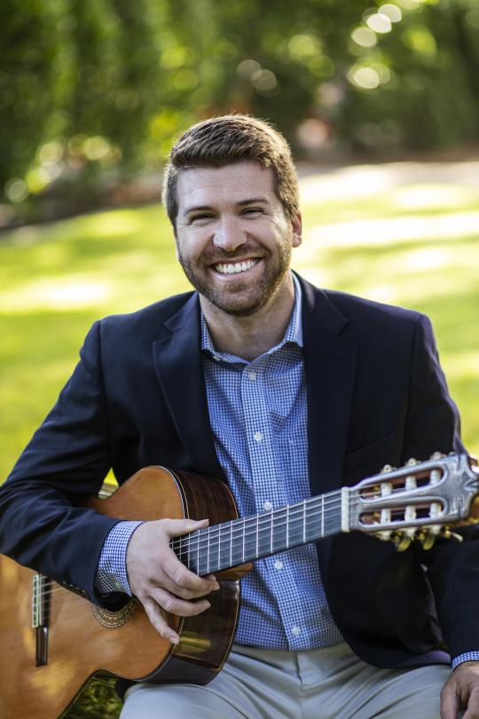 Cody Martin Headshot holding a guitar