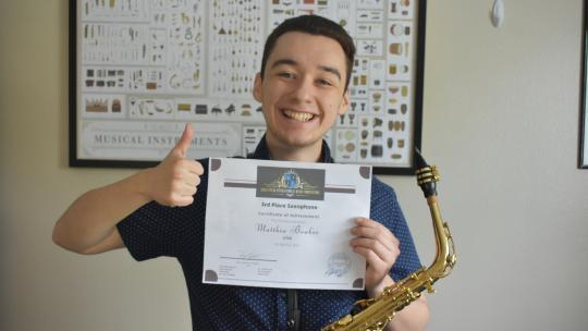 Matthew Bowker holding up certificate 