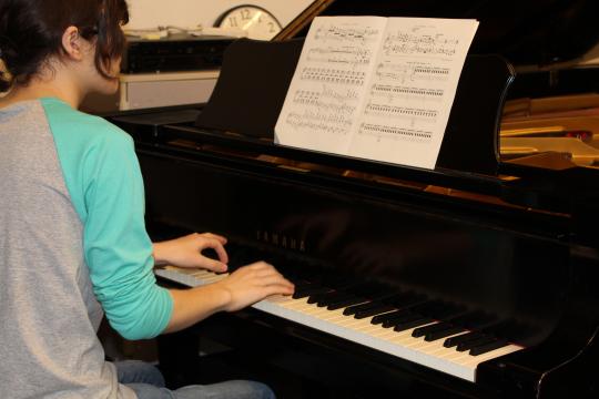 student sitting at piano ready to play