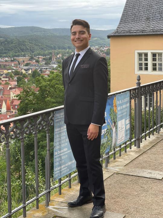 Jack Adkins standing in a suit near railing outdoors