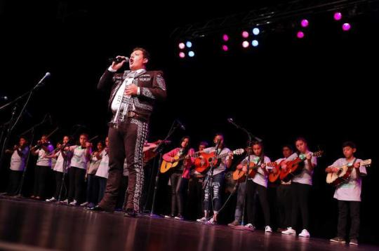 José Soto Jr. singing in front of a group of mariachi students