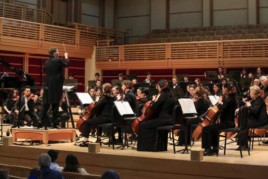 Dr. Kahn conducting the orchestra on stage