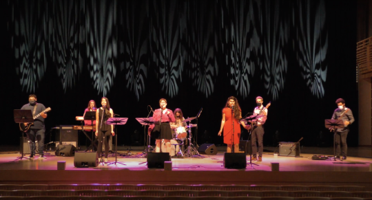 Band onstage at Weill hall with three female singers