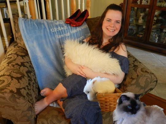 Madelyn Conner, sitting on a chair holding a pillow