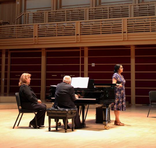 Vocal student on stage ready to perform with pianists