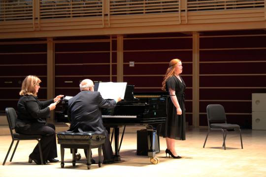 Girl standing in front of piano to sing