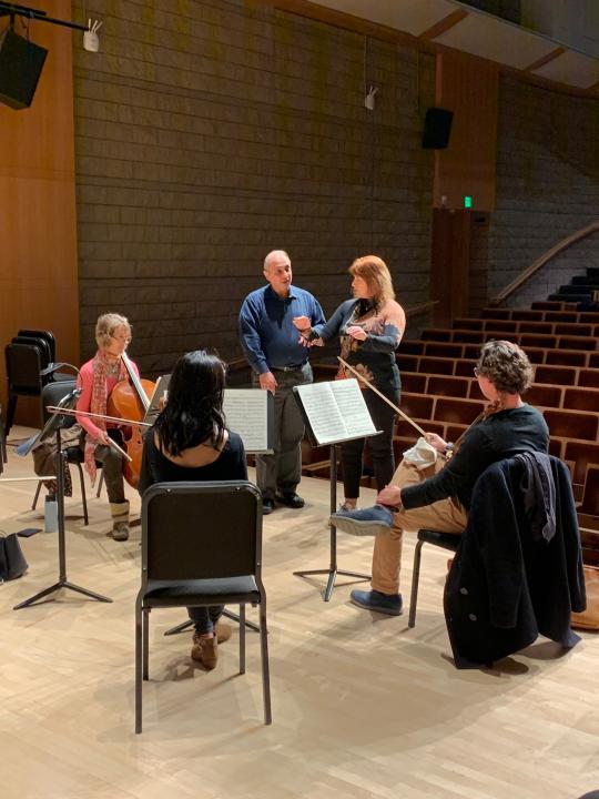 Orchestra instruction on stage with small ensemble