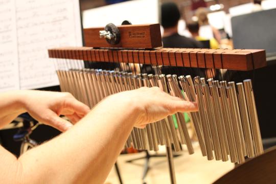 This musician is using her hands to play the little chimes